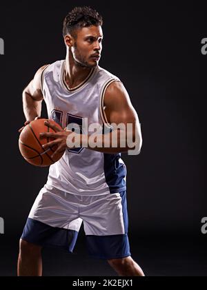 Spiel. Studioaufnahme eines Basketballspielers vor schwarzem Hintergrund. Stockfoto