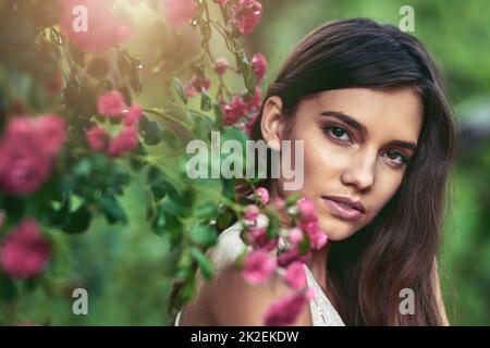 Ihre Schönheit wird Sie verzaubern. Eine kurze Aufnahme einer schönen jungen Frau, die in der Natur posiert. Stockfoto