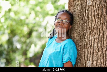 Shes ein Naturliebhaber. Aufnahme eines hübschen Teenagers, das sich an einen Baum lehnt. Stockfoto