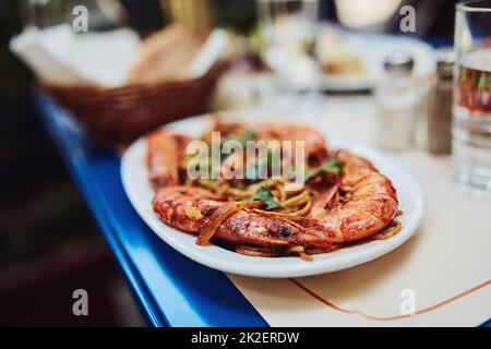 Gutes Essen lohnt sich. Kurzer Schuss eines köstlichen Garnelengerichtes, das in einem Restaurant serviert wird. Stockfoto