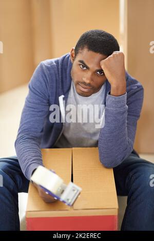 HES Umzug. Ein hübscher junger Mann, der Kisten verpackt. Stockfoto