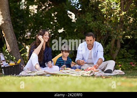 Picknicks wurden für den Sommer gemacht. Aufnahme einer Familie, die zusammen ein Picknick genießt. Stockfoto