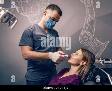 Zahnärzte untersuchen die Farbe der Zähne Stockfoto