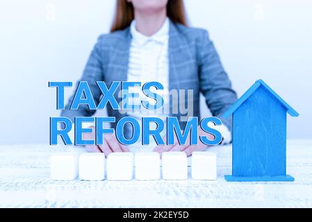 Schild mit Steuerreformen. Ein Wort über die Verwaltung der erhobenen Steuern in einem effizienteren Prozess Eine junge Dame Orbusinesswoman Holding oder Presecting Home in Business Outfit Stockfoto