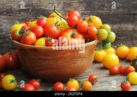 Hölzerne Schüssel mit frischem Wein gereift heirloom Tomaten aus Farmers Market Stockfoto