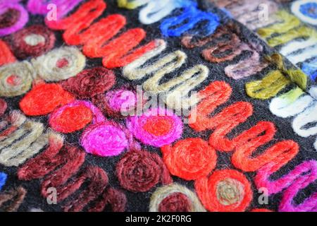 Buntes Strickmaterial Hintergrundstruktur, farbenfrohes Material mit Muster, Matte Nahaufnahme, mehrfarbige Leinwand, Struktur aus Leinen, abstrakt, Fragmentierter farbiger Teppich. Stockfoto