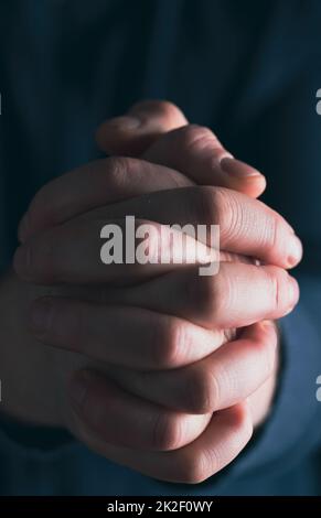 Männerhände in Gebetsposition, tiefes Bild Stockfoto