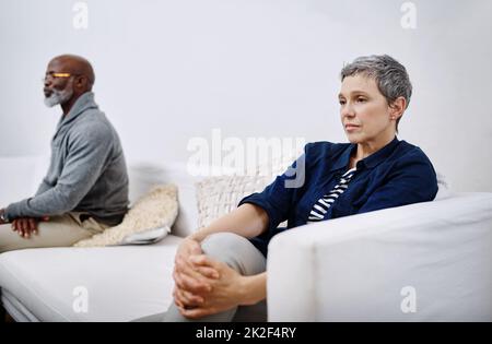 Waren nicht mehr auf Sprechzeiten. Aufnahme eines unglücklichen älteren Paares, das getrennt auf einer Couch saß, nachdem es zu Hause einen Streit geführt hatte. Stockfoto