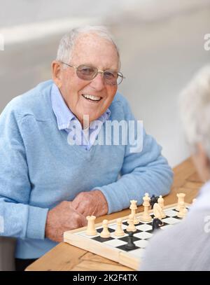 Schachmatt in fünf Zügen.... Ein älteres Paar, das gemeinsam Schach spielt. Stockfoto