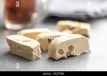 Süße Tahini-Halva mit Mandeln. Türkischer Desserttisch, grau. Stockfoto