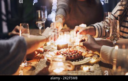 Beleuchten Sie Ihr Leben mit guten Freunden. Eine kurze Aufnahme einer Gruppe von Freunden, die mit Wunderkerzen auf einer Weihnachts-Dinner-Party spielen. Stockfoto