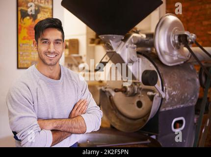 Hier beginnt die Tasse Kaffee. Eine Maschine, die Kaffeebohnen mahlen und rösten lässt. Stockfoto