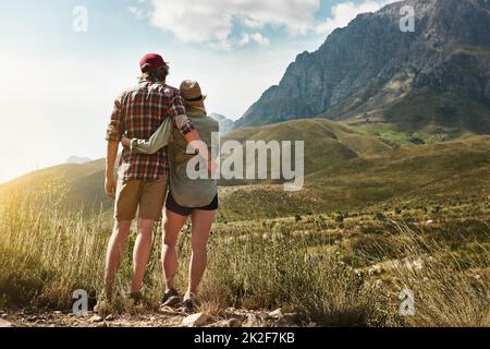 Liebe inspiriert von der Schönheit der Natur. Rückansicht eines jungen Paares, das einen Bergblick in der Natur bewundert. Stockfoto