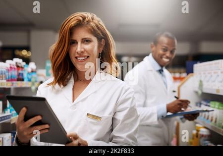 Waren 24 Stunden für Sie geöffnet. Porträt zweier Apotheker, die in einem Chemiker zusammenarbeiten. Stockfoto