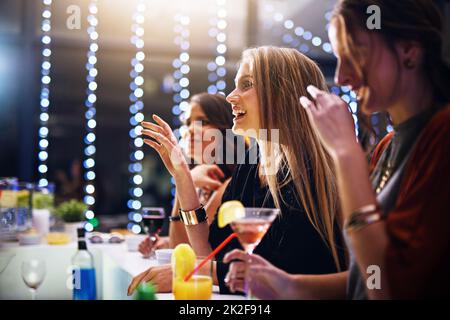 Sie haben ihre Lieblingsgetränke bestellt. Eine kurze Aufnahme einer Gruppe von Freunden, die auf einer Party zusammen Getränke trinken. Stockfoto