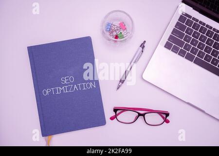 Textbeschriftung mit Seo Optimization. Geschäftsprozesse zur Beeinflussung der Online-Sichtbarkeit von Websites oder Seiten Bürobedarf über Schreibtisch mit Tastatur und Brille und Kaffeetasse für die Arbeit Stockfoto