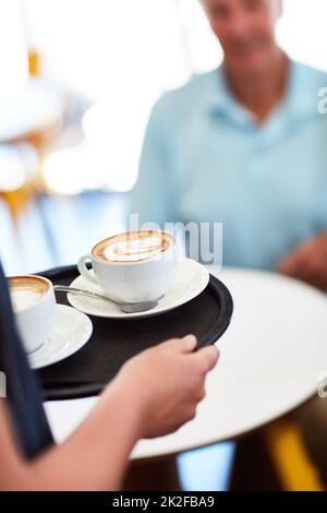 Mit Kaffee wird alles besser. Kurzer Schuss einer Kellnerin mit zwei Kaffees. Stockfoto