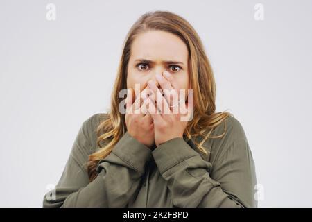 Warum sollten Sie das tun? Studioaufnahme einer jungen Frau, die vor grauem Hintergrund schockiert aussieht. Stockfoto