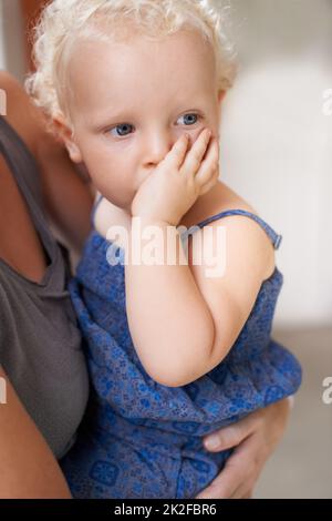 Sicher in Mummys Armen. Ein süßes kleines Mädchen, das in den Armen ihrer Mutter sitzt. Stockfoto