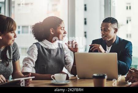 Das ist ein interessanter Punkt Eine kleine Aufnahme eines hübschen jungen Geschäftsmannes, der sich während einer Sitzung im Sitzungssaal an seine Kollegen wendet. Stockfoto