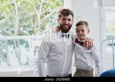 Mit Vandy. Porträt eines entzückenden kleinen Jungen und seines Vaters, der zu Hause in passenden Outfits gekleidet ist. Stockfoto