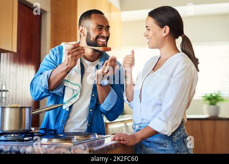 Schmeckt es gut? Aufnahme eines Paares, das zu Hause zusammen kocht. Stockfoto