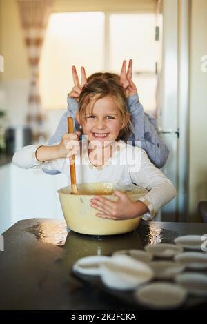 Spaß und Erinnerungen. Eine kurze Aufnahme von zwei jungen Geschwistern, die Spaß beim gemeinsamen Backen zu Hause haben. Stockfoto