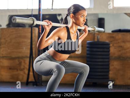 Heben Sie, wie Ihr Leben davon abhängt. Aufnahme einer jungen Frau, die in einem Fitnessstudio mit Gewichten arbeitet. Stockfoto