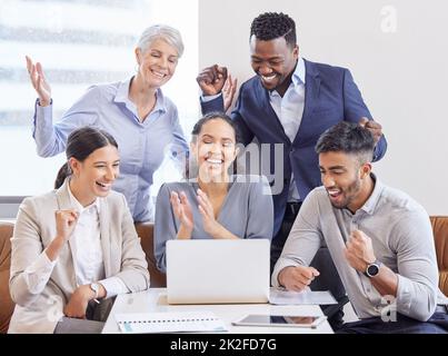 Selbstständiges Arbeiten auf ein Ziel hin. Aufnahme einer Gruppe von Kollegen, die in einem Büro jubeln. Stockfoto