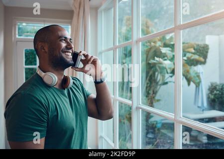 Es ist toll, Ihre Stimme wieder zu hören. Aufnahme eines jungen Mannes, der mit seinem Smartphone telefoniert. Stockfoto