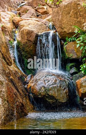 Kleiner Wasserfall zwischen Steinen Stockfoto