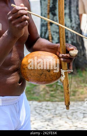 Musiker, der während einer Capoeira-Performance ein traditionelles brasilianisches Schlagzeuginstrument namens Berimbau spielt Stockfoto