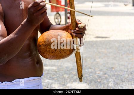 Musiker, der traditionelle Instrumente spielt, die in Capoeira in Salvador, Bahia, verwendet werden Stockfoto