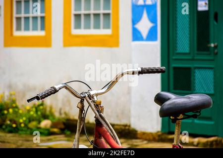 Altes Fahrrad hielt vor den Häusern im Kolonialstil Stockfoto