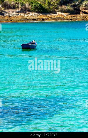 Hölzernes Fischerboot, das auf dem farbenfrohen und transparenten Wasser schwimmt Stockfoto