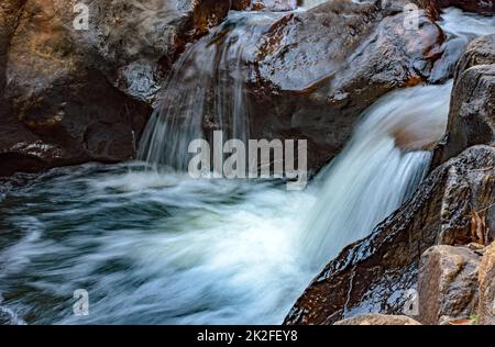 Kleiner Fluss mit klarem Wasser und Kaskade, die durch die Felsen fließt Stockfoto