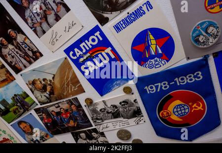 PRODUKTION - 21. September 2022, Sachsen, Auerbach: Bilder mit Autogrammen von Kosmonauten, Wimpeln und Plakaten zum Interkosmos-Programm hängen in einem DDR-Kinderzimmer im Museum in Auerbach. An diesem Wochenende öffnet die DDR-Wohnung im Stadtmuseum Auerbach ihre Pforten für Besucher. Ein Privatsammler hatte beschlossen, seine Schätze der Öffentlichkeit zugänglich zu machen. Zuvor hatte er die Gegenstände in einer 80 Quadratmeter großen Wohnung der Wohnungsgenossenschaft Auerbach gesammelt. Die Show basiert auf einer neuen DDR-Wohnung aus dem Jahr 1980s. Auf einem Rundgang durch das Wohnzimmer, Bad, Stockfoto