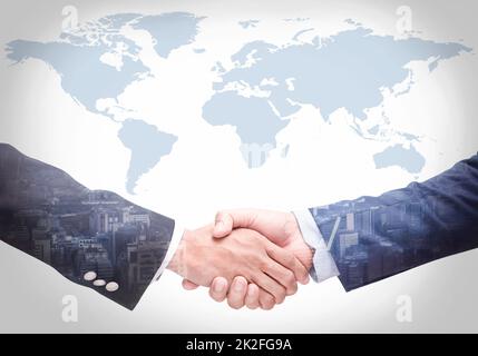 Geschäftsleute schütteln sich die Hände mit einer Karte im Hintergrund, Vereinbarung, Zusammenarbeit, Nahaufnahme Stockfoto