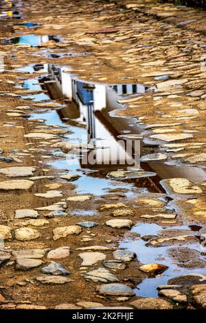 Reflexionen eines alten Hauses im Kolonialstil in einer Pfütze auf der Paraty City Street Stockfoto