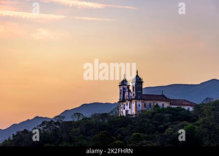 Alte und historische Kirche auf dem Hügel während des Sonnenuntergangs in Ouro Preto Stadt Stockfoto