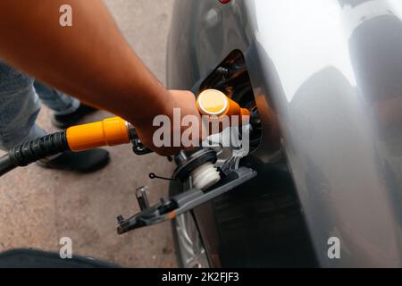 Handmann Nachfüllen und Öl-Gas-Kraftstoff an der Station füllen. Tanken von Autos mit Benzin oder Diesel mit einem Zapfsäule. Kraftstoff für das Geschäft Stockfoto