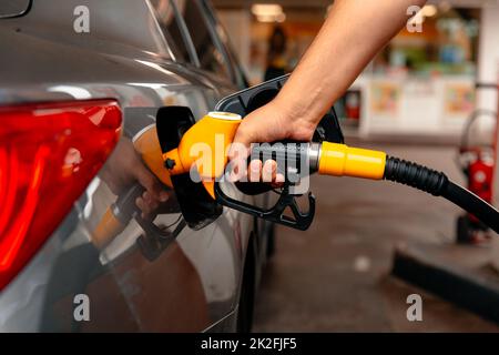 Handman Nachfüllen und Betanken von Öl Gas Kraftstoff an der Tankstelle. Pistolenbenzin in den Tank zum Befüllen. Beleben Sie Ihr Geschäft Stockfoto