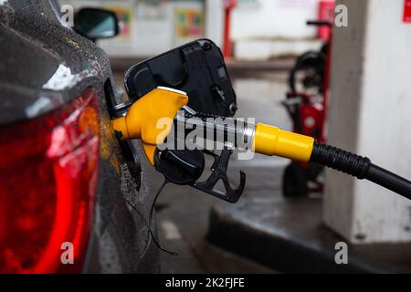 Betankungspistole im Gastank, das Konzept der steigenden Kraftstoffpreise. Stockfoto