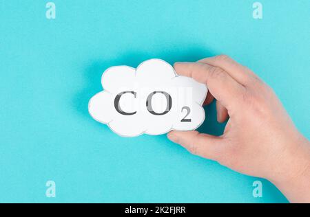 Hand hält Wolke mit dem Wort CO 2, Kohlendioxid-Emission, Umweltproblem, Luftverschmutzung Stockfoto