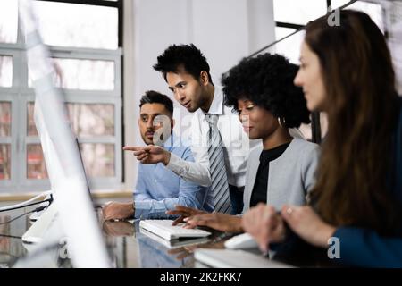 Zufriedene Geschäftsleute, Die Am Arbeitsplatz Mit Notebooks Diskutieren Stockfoto