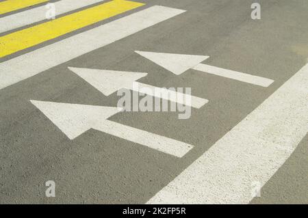 Asphaltierte Straße mit Pfeil zeigt die Richtung der Bewegung Stockfoto