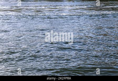 Wasseroberfläche mit Wellen und Wellen und reflektierendem Sonnenlicht Stockfoto
