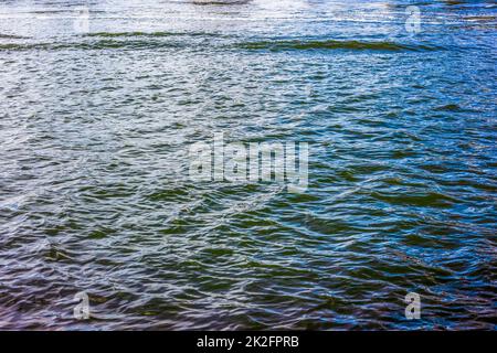 Wasseroberfläche mit Wellen und Wellen und reflektierendem Sonnenlicht Stockfoto