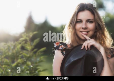 Porträt einer jungen Frau mit schwarzem Strohhut. Stockfoto