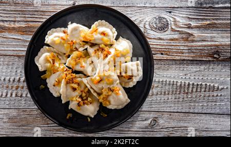 Komposition mit einem Teller klassischer Pierogien mit Zwiebeln Stockfoto